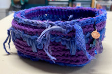Load image into Gallery viewer, A crochet basket made from chunky purple and blue yarn, featuring sari silk details with a small round copper charm and amethyst bead.
