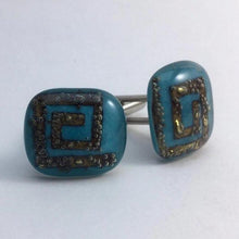 Load image into Gallery viewer, A pair of light-blue fused-glass cufflinks with brass spirals.
