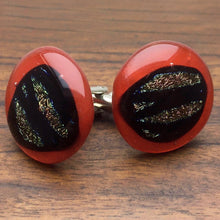 Load image into Gallery viewer, A pair of red fused-glass cufflinks with dichroic features.
