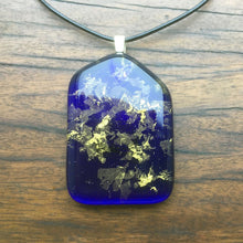 Load image into Gallery viewer, A blue fused-glass pendant with 24-carat gold flakes.
