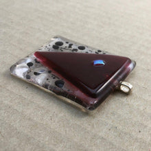 Load image into Gallery viewer, A red and clear fused-glass pendant with a dichroic feature and black spots.

