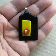 Load image into Gallery viewer, A black and yellow fused-glass pendant with a dichroic feature.
