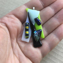 Load image into Gallery viewer, A green, black and white fused-glass pendant with dichroic features.
