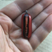 Load image into Gallery viewer, A red fused-glass pendant with a dichroic stripe.
