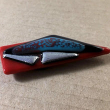 Load image into Gallery viewer, A red fused-glass magnet with silver dichroic features.
