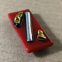 Load image into Gallery viewer, A red fused-glass magnet with silver and gold dichroic features.
