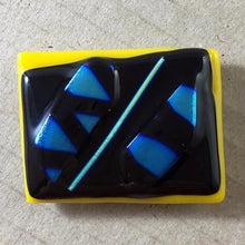 Load image into Gallery viewer, A yellow and black fused-glass magnet with blue dichroic features.
